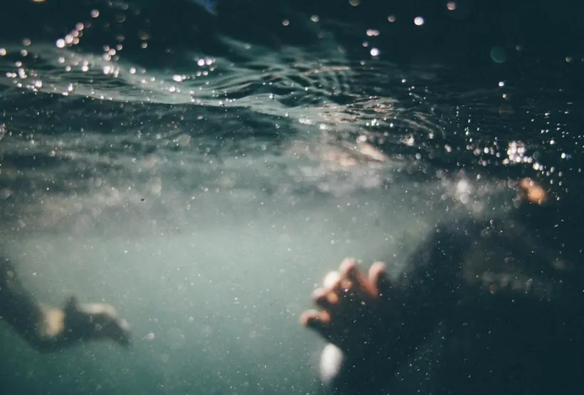 A hand reaching through the water during a stroke