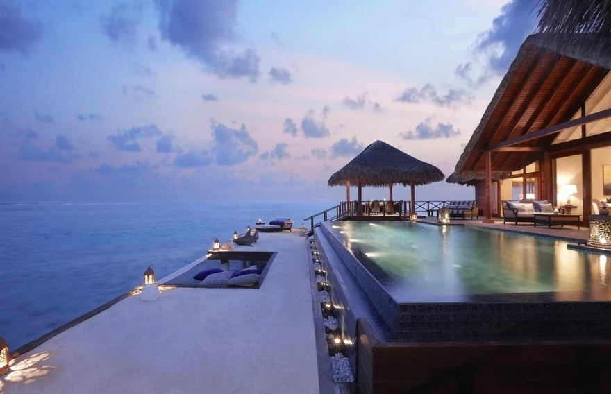 A pool terrace by the sea at dusk